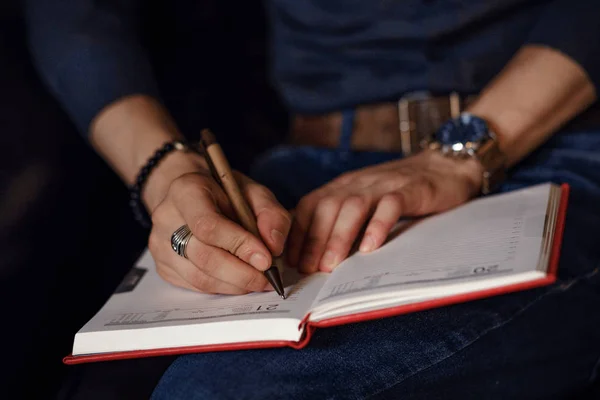 Man die aantekeningen maakt in een notitieboekje — Stockfoto