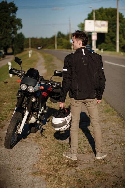 Disparo de los motociclistas hacia atrás, de pie cerca de su moto — Foto de Stock