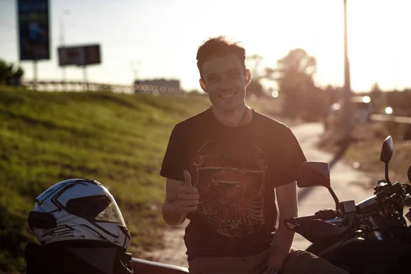 Yakışıklı genç motorcu Ok işaretleri gösteriyor — Stok fotoğraf