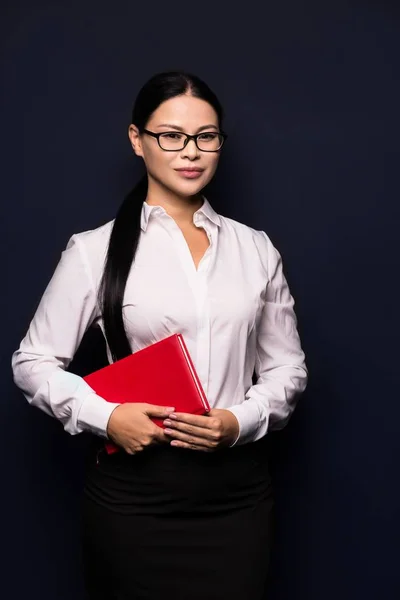 Mujer de negocios sonriente sosteniendo cuaderno rojo — Foto de Stock