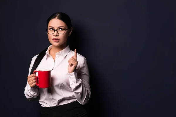 Empresária desfrutando de coffee break segurando copo vermelho — Fotografia de Stock