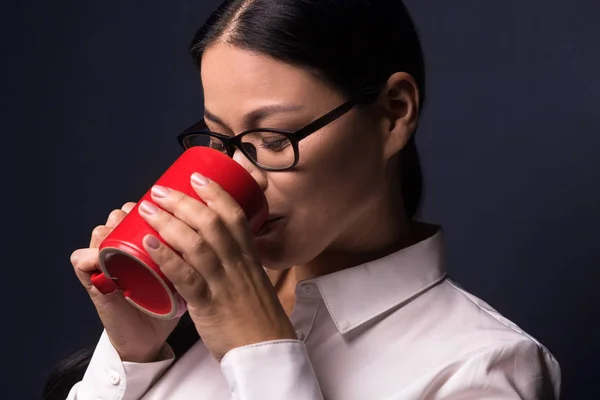 Affärskvinna njuter kaffepaus holding röd kopp — Stockfoto