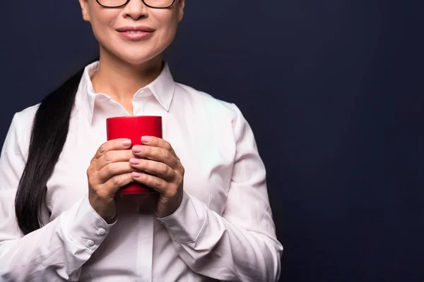 Mujer de negocios disfrutando de un descanso de café sosteniendo la taza roja — Foto de Stock