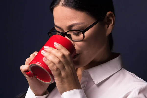 Mujer de negocios disfrutando de un descanso de café sosteniendo la taza roja —  Fotos de Stock