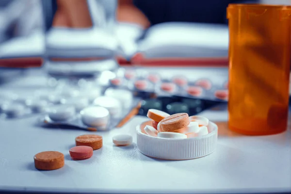 Close-up view on the pills in bottles cap laying on the table — Stock Photo, Image