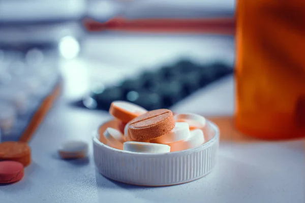 Visão de close-up sobre as pílulas em garrafas tampa que coloca sobre a mesa — Fotografia de Stock