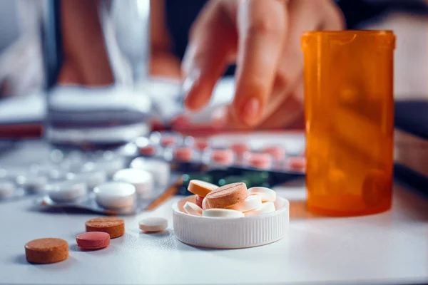 Vista de cerca de las píldoras en frascos tapa puesta sobre la mesa — Foto de Stock