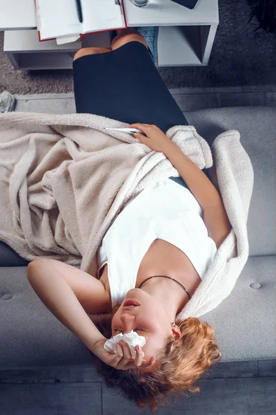 Возвышенный вид на больную женщину, лежащую с рукой на лбу — стоковое фото