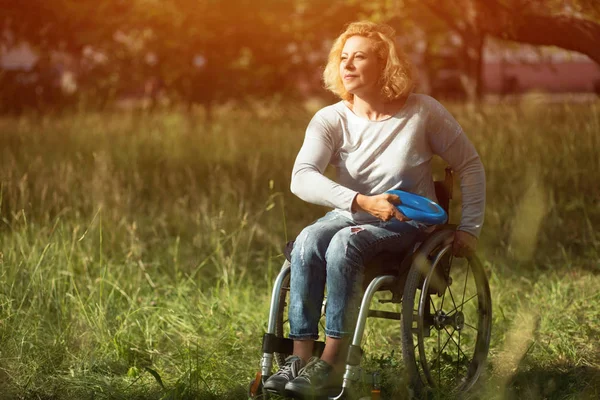 Tekerlekli sandalye kadında frizbi atar — Stok fotoğraf