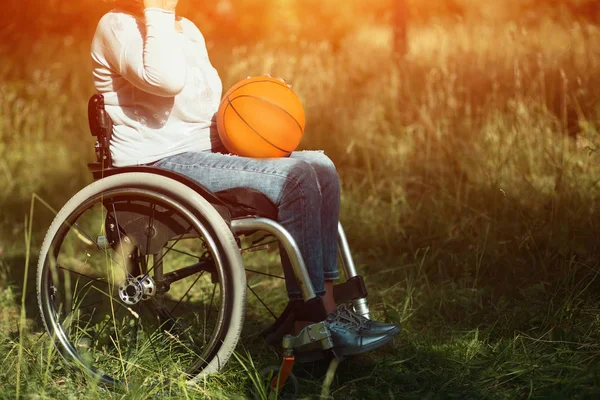 Vrouw in rolstoel met mand bal op haar ronden — Stockfoto