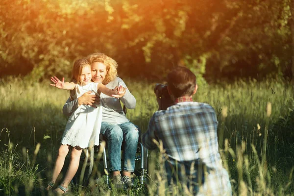 Professianl fotoğrafçı kadının fotoğrafını tekerlekli sandalyede alır. — Stok fotoğraf