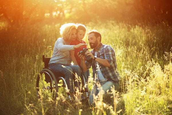 Photographe prend des photos de famille heureuse où la femme est en fauteuil roulant — Photo