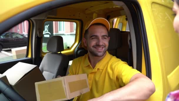 Courier σε κίτρινο φορτηγό πακέτο δίνει θηλυκό πελάτη — Αρχείο Βίντεο