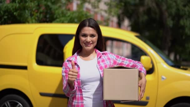 Leende kvinna i casual håller paketet och visar ok tecken — Stockvideo