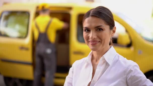 Femme d'affaires souriante montrent ok. Camion de livraison floue et courrier à l'arrière-plan — Video