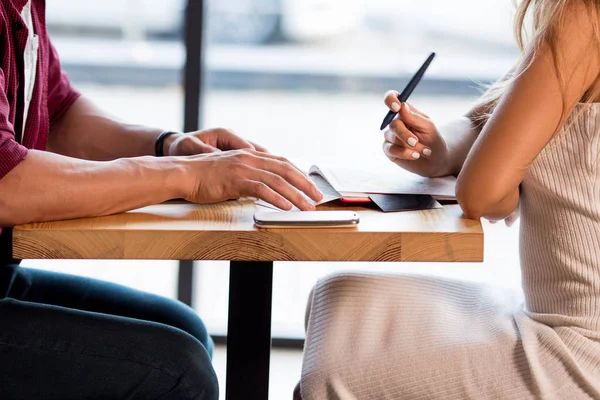 Amada Pareja Joven Haciendo Notas Mientras Está Sentada Café Haciendo — Foto de Stock