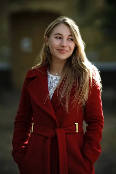 Mujer joven caminando usando abrigo rojo — Foto de Stock