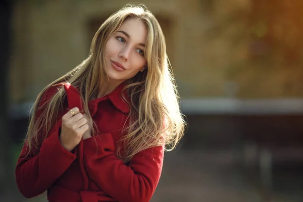 Mujer joven caminando usando abrigo rojo — Foto de Stock