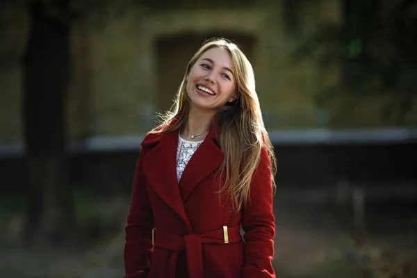 赤いコートを着て歩いている若い女性 — ストック写真