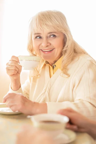 Улыбающаяся старуха пьет чай. Портрет — стоковое фото
