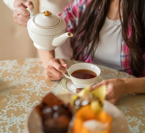 Hälla te från porslin tekanna till cup. — Stockfoto