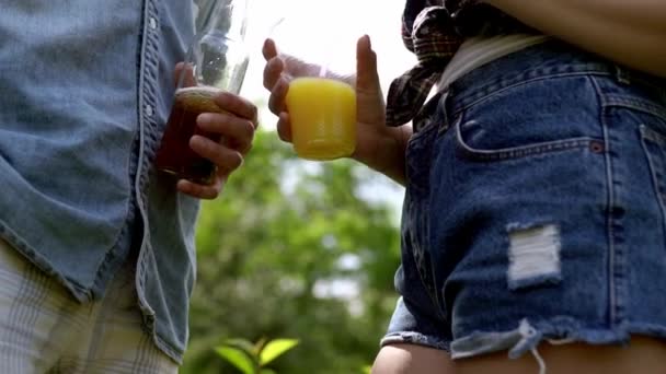 Below shot of bottle of beer and orange juice in peoples hands — Stock Video