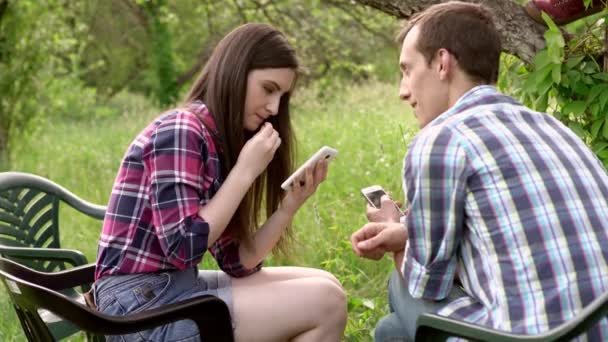 Dva přátelé sedí a ukazuje fotografie na telefony — Stock video