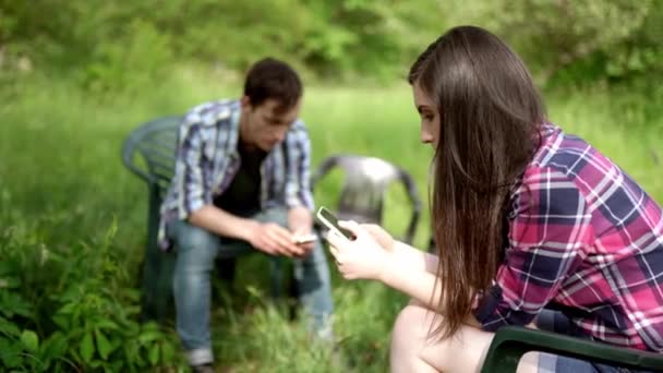 Two friends sitting and showing photos on the phones — Stock Video