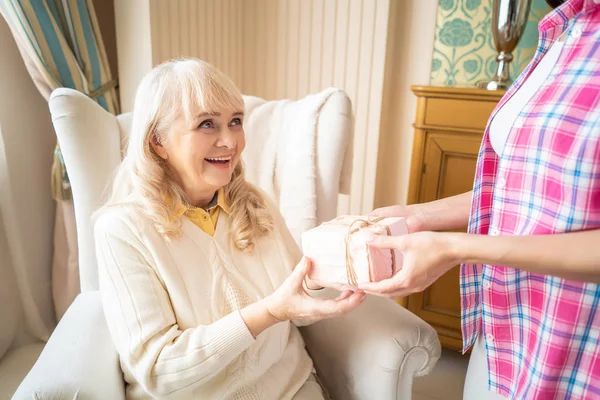 Smiling daughter is giving to her mother a lovely present — Stock Photo, Image