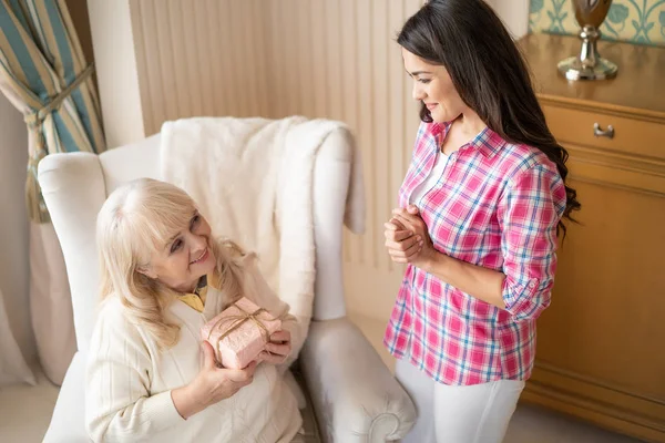 Sorrindo filha está dando a sua mãe um lindo presente — Fotografia de Stock