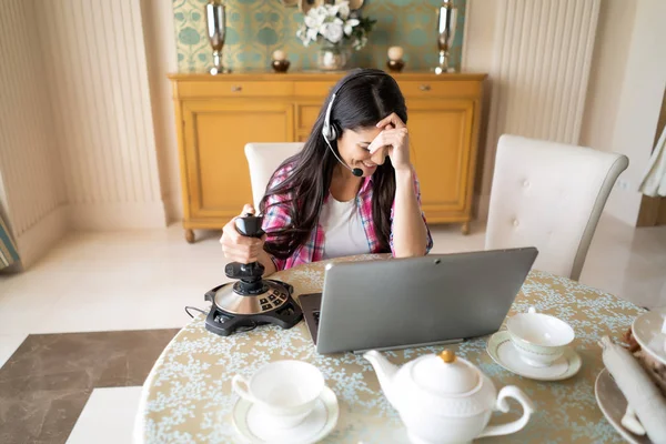 Bella donna gioca con un joystick retrò sul computer portatile — Foto Stock