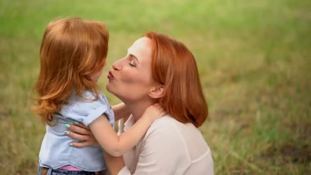 Beautiful mother kisses her child outdoor — Stock Video