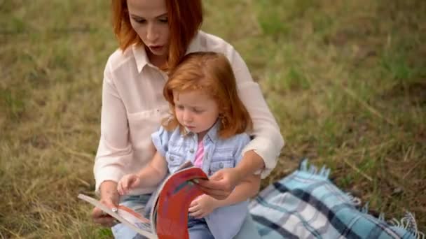 Mom Cute Little Daughter Reading Fairy Tales Spring Green Park — Stock Video