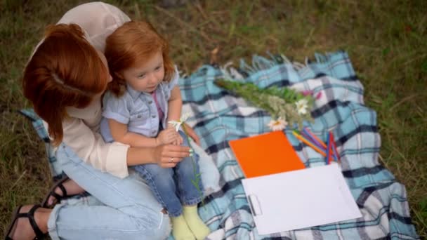 Mutter und Tochter spielen mit Kamille im Freien — Stockvideo