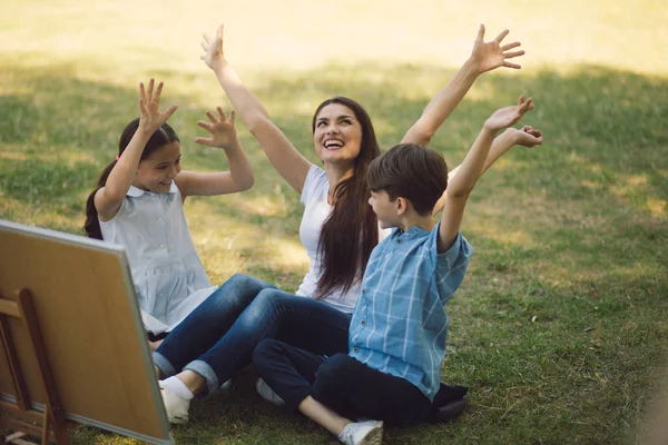 Kinderen en leraar poserend met opgeheven handen — Stockfoto