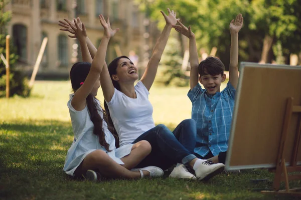 Kinderen en leraar poserend met opgeheven handen — Stockfoto