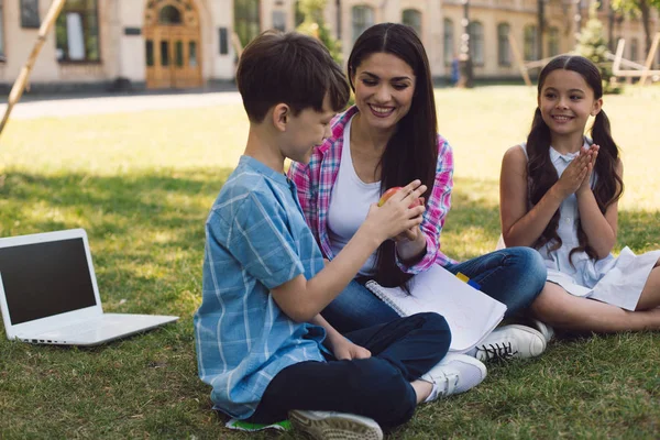 Insegnante dando mela al bambino — Foto Stock