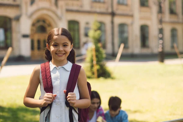 美丽的小学生站在与 rucksak — 图库照片