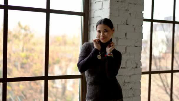 Досить азіатська жінка танцює через вікно в приміщенні — стокове відео