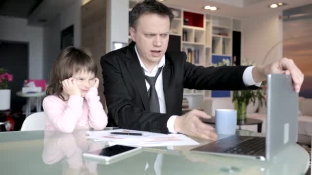 Бизнесмен работает на дому и заботится о своей маленькой дочери. — стоковое видео