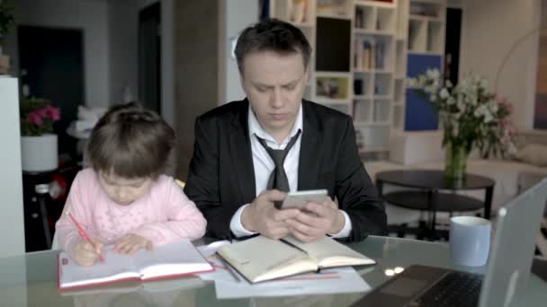 Uomo d'affari lavora da casa e si prende cura della sua piccola figlia — Video Stock