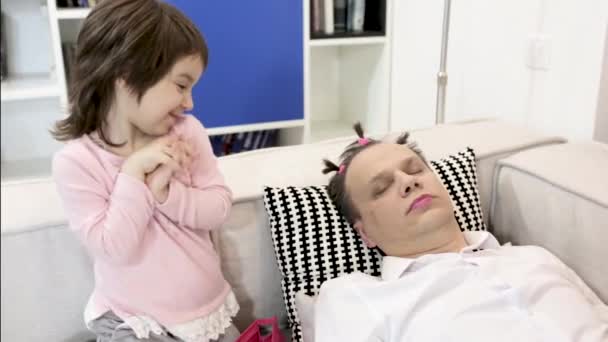 Hijita aplica maquillaje a padre dormido — Vídeo de stock