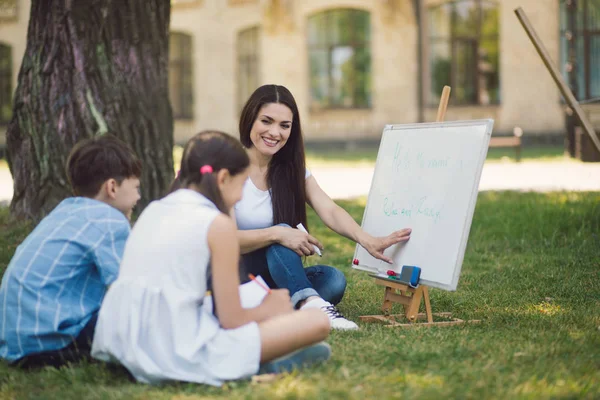 Gruppo di bambini con insegnante nel parco — Foto Stock