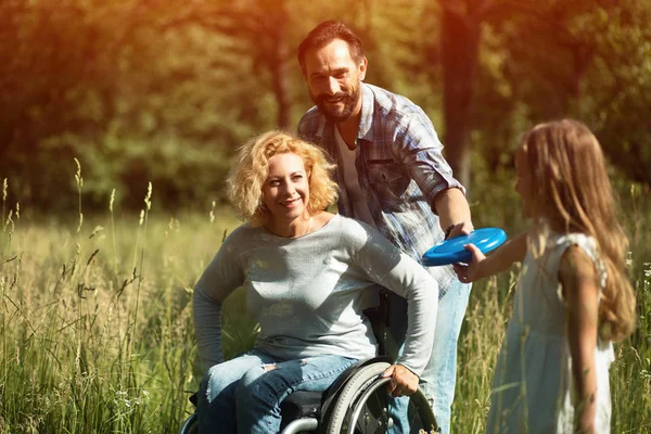 Young daughter gives Frisbeeto her disabled mother — Stock Photo, Image