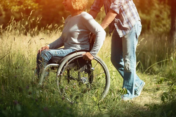 Man pushes the wheelchair with his girlfriend, — Stock Photo, Image