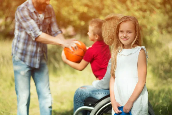 Small daugher of a disabled woman is smiling at camera — Stock Photo, Image