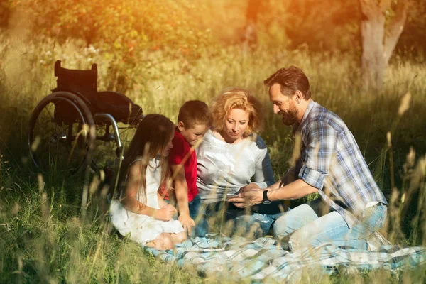 Parkta piknik üzerinde mutlu aile alarak selfie. Belden aşağısı felçli — Stok fotoğraf