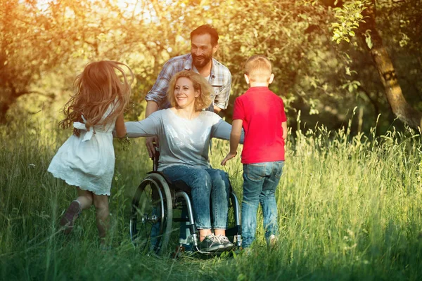 Children run to their disabled mother in the park — Stock Photo, Image