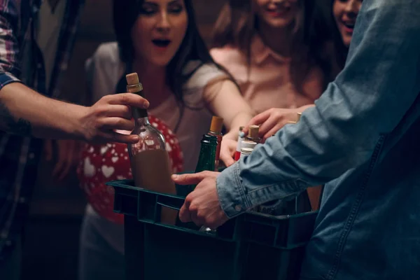 Uomo che tiene la scatola con bottiglie di champagne a una festa — Foto Stock