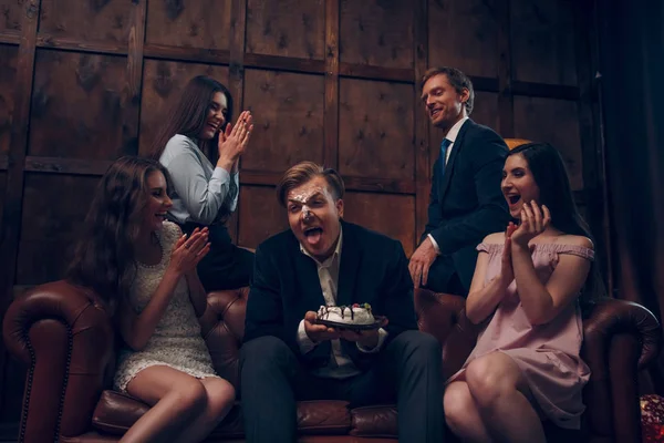 Bonito rosto de homem coberto de bolo de aniversário — Fotografia de Stock